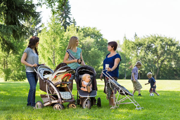 Moms and their kids talking at the park