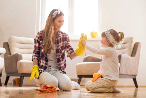 Mom and daughter cleaning up a messy room. Getting your child to clean up requires patience.