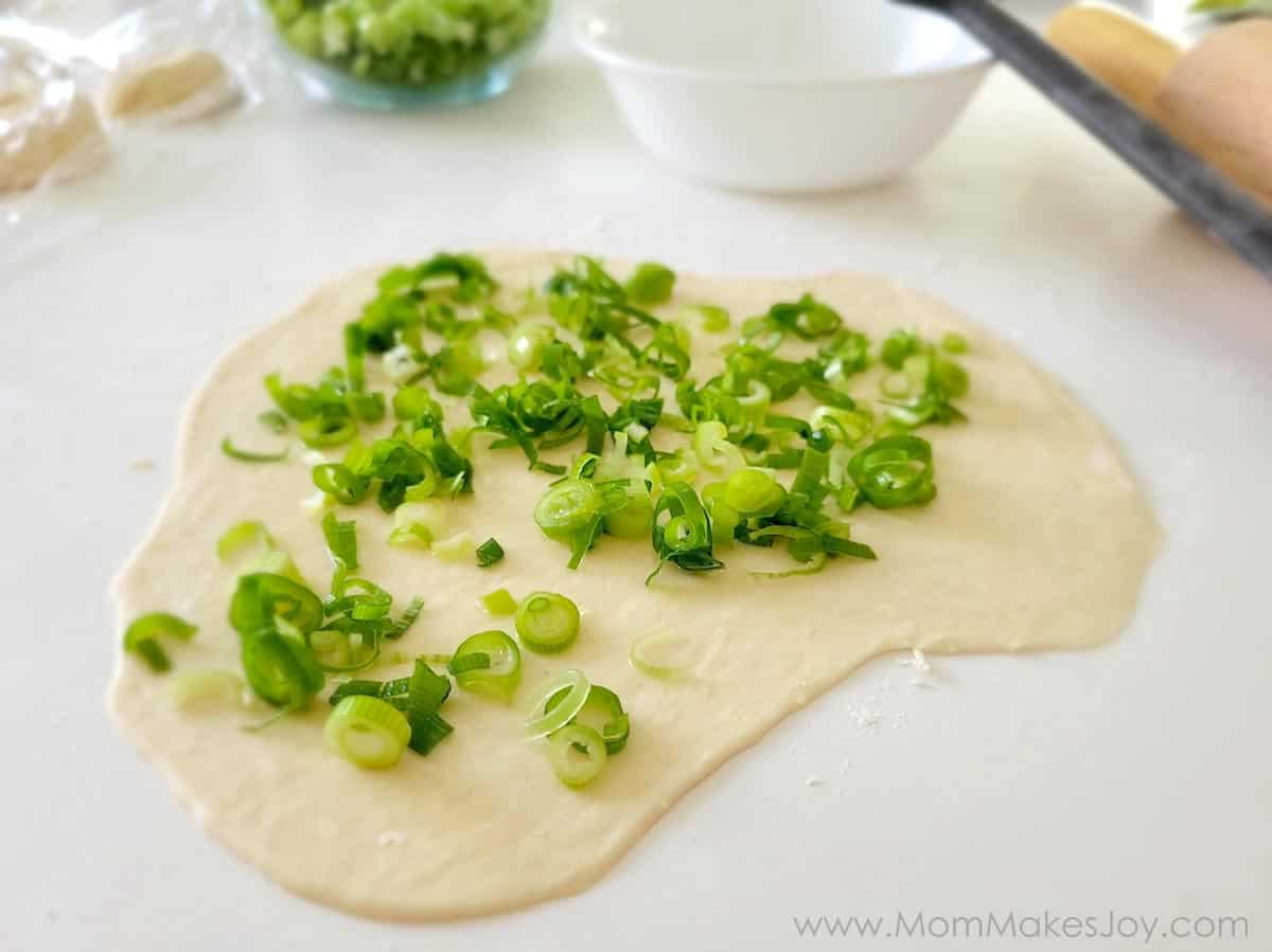 Scallions placed on the dough with salt