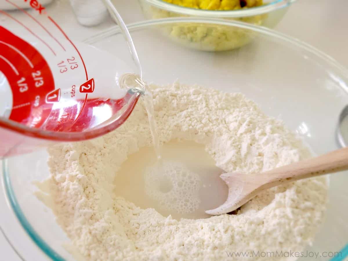 Pouring warm water into a well of flour